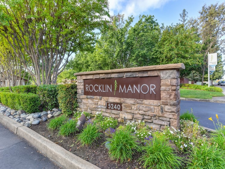 Rocklin Manor Monument Sign- Close Up with Plant Bed, Road and Trees